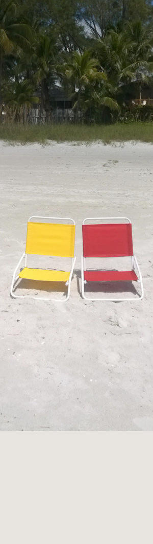 Zwei bunte Stühle am Strand